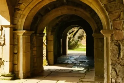 Un arco gótico medieval que se ergue sobre pilares de granito desgastado