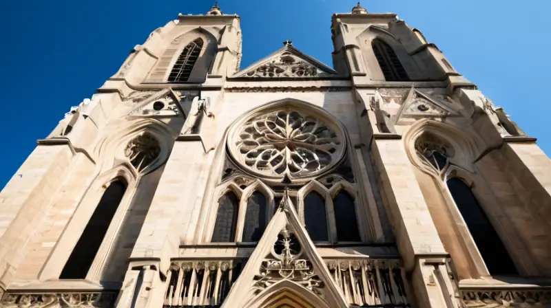 La catedral gótica muestra un exterior desgastado con detalles finos y un cielo azul velado por nubes ligera