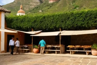 La calle empedrada de un pueblo antiguo se desciende en medio de una valle rodeado de montañas verdes