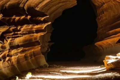 Una cueva con una entrada empeñada se extiende en la oscuridad de un roquedo