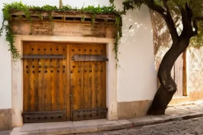 Un pintoresco porche de una charcutería con una fuente clásica y un cielo azul vago en la distancia